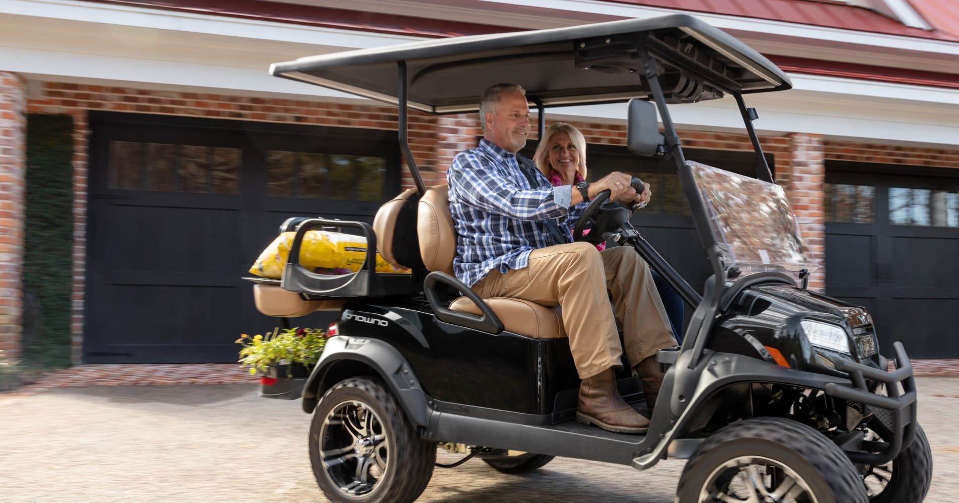 man and woman riding in an Onward golf cart